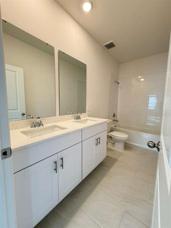 2265 Hen Road Minneola, FL 34715 - Photo 27 of 36 a bathroom with a double vanity sink mirror and toilet