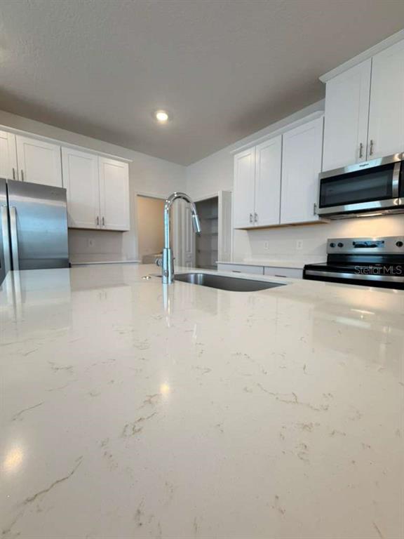 2265 Hen Road Minneola, FL 34715 - Photo 7 of 36 a view of a kitchen with stainless steel appliances