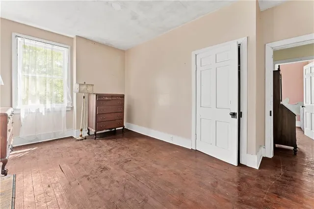 a view of an empty room with closet and a window