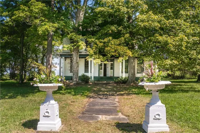 a front view of a house with a yard and fountain in middle