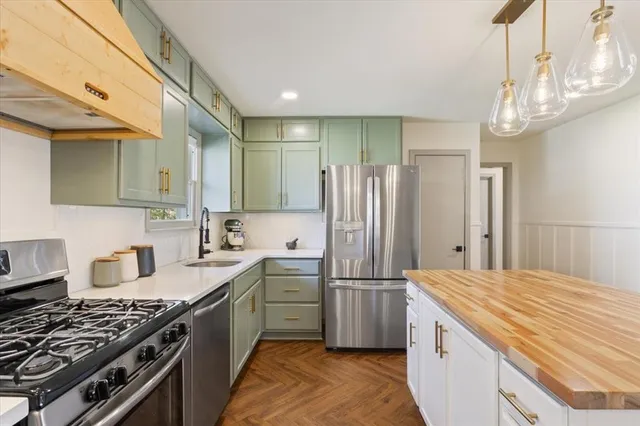 a kitchen with refrigerator a stove a sink and cabinets