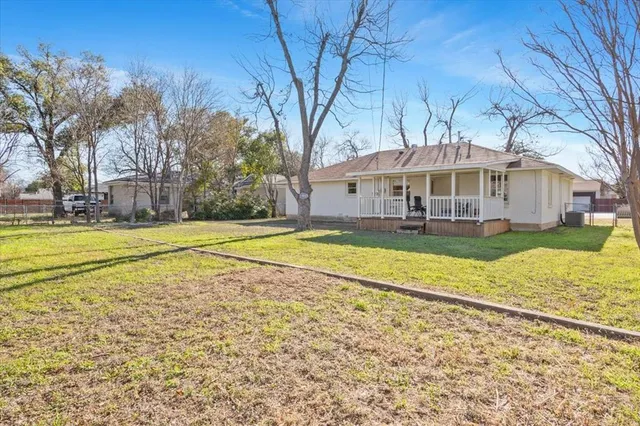 a view of a house with a big yard and large trees