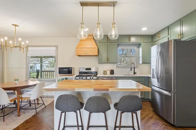 a kitchen with stainless steel appliances a table chairs and a refrigerator