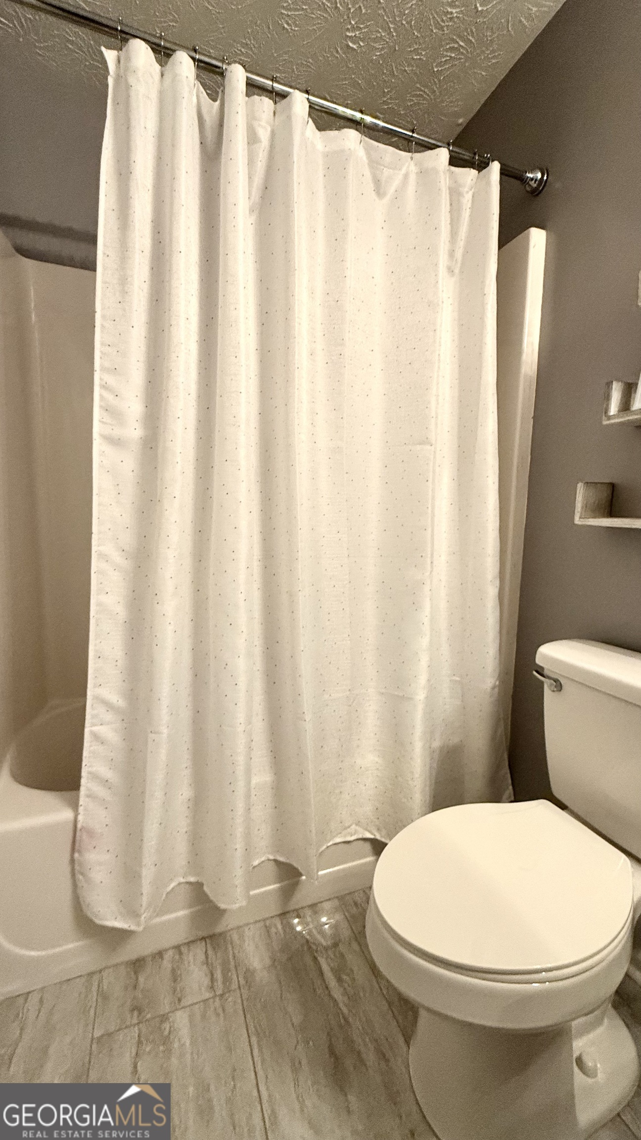 110 Waterloo Drive Mount Airy, GA 30563 - Photo 11 of 24 a white toilet sitting next to a white curtain
