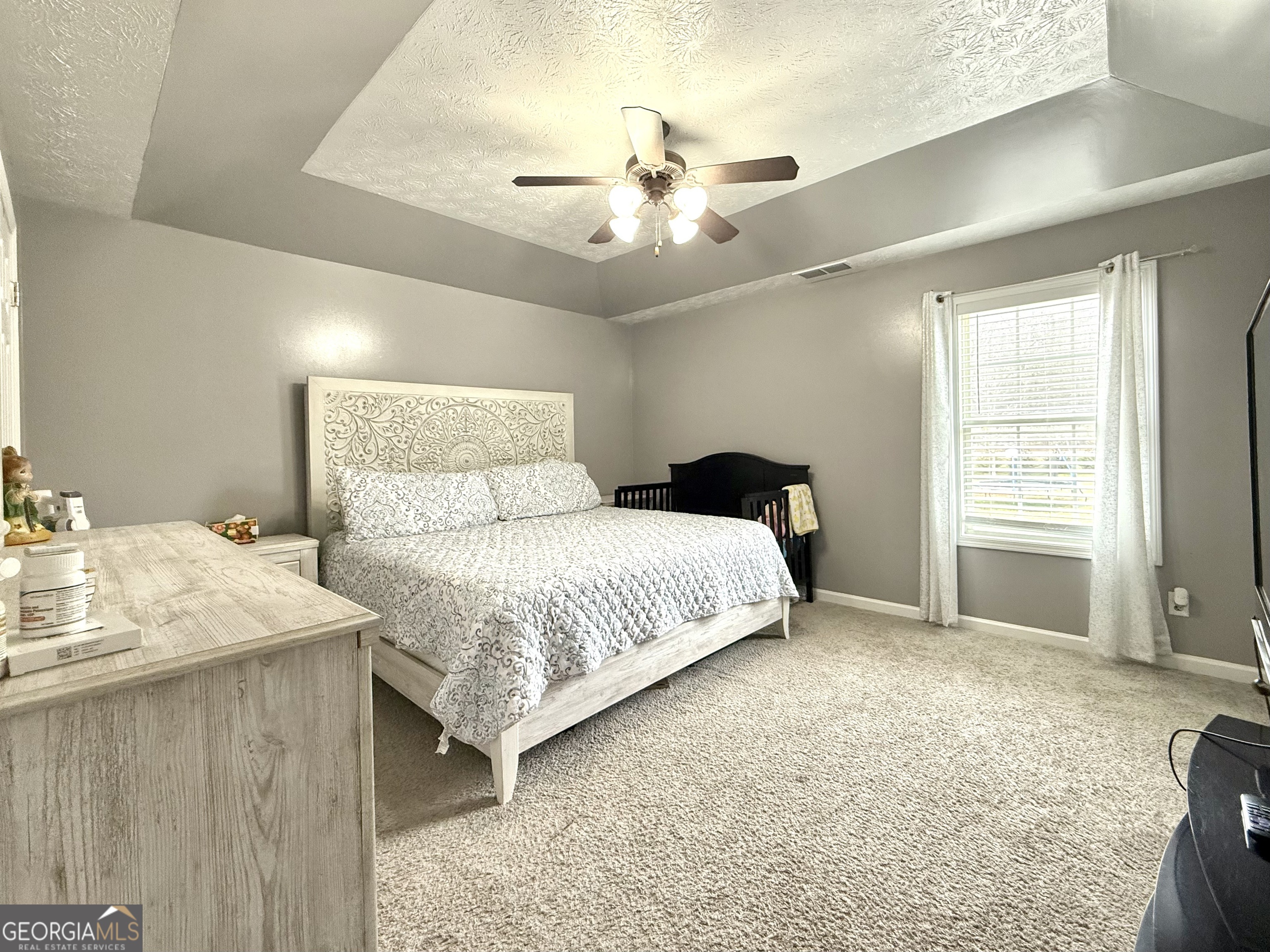 110 Waterloo Drive Mount Airy, GA 30563 - Photo 14 of 24 a bedroom with a bed and a chandelier