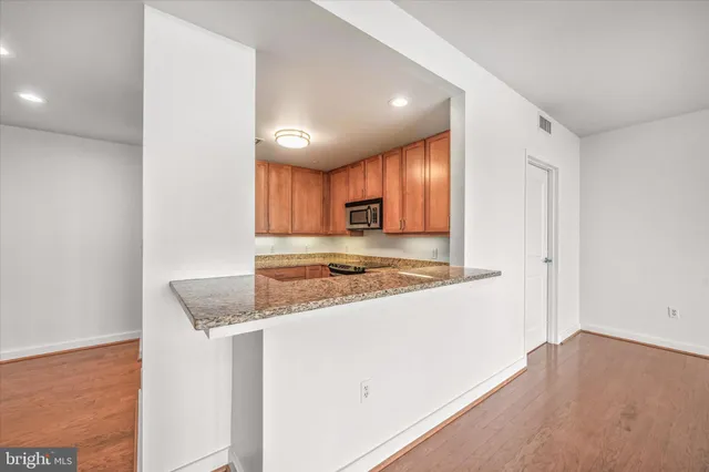 a view of a kitchen with a sink and dishwasher a refrigerator with wooden floor