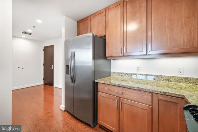 a kitchen with stainless steel appliances granite countertop a refrigerator and a sink