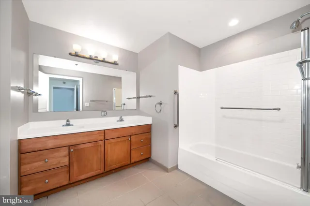a spacious bathroom with a tub sink shower and mirror