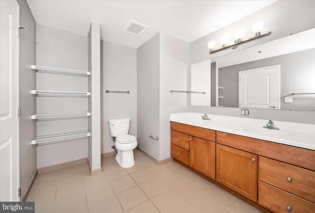 a spacious bathroom with a double vanity sink mirror and toilet