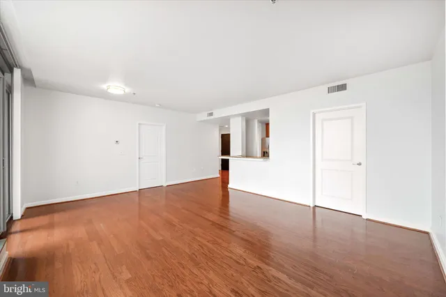 a view of empty room with wooden floor