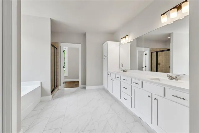 a spacious bathroom with a double vanity sink a mirror and a bathtub