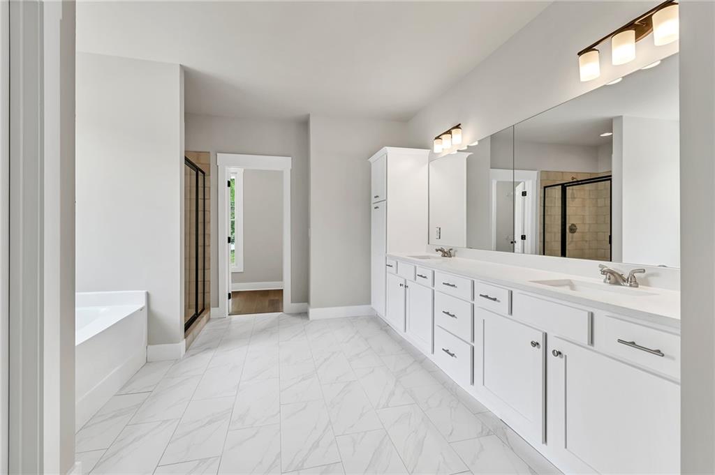 231 East Marable Street Monroe, GA 30655 - Photo 14 of 36 a spacious bathroom with a double vanity sink a mirror and a bathtub