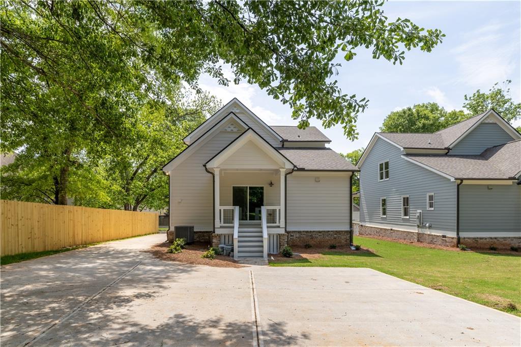 231 East Marable Street Monroe, GA 30655 - Photo 28 of 36 front view of house with a yard and trees all around