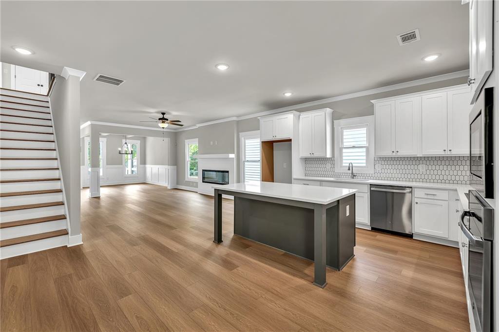 231 East Marable Street Monroe, GA 30655 - Photo 8 of 36 a kitchen with granite countertop a stove top oven and cabinets