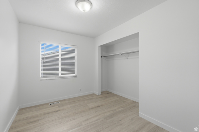 7910 Woolley Way Magna, UT 84044 - Photo 16 of 26 Interior room featuring light wood-finish flooring, white baseboards, and a neutral wall color