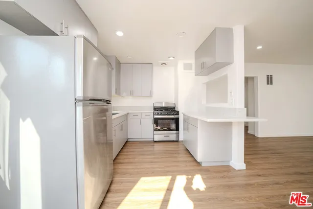 a kitchen with white cabinets and appliances