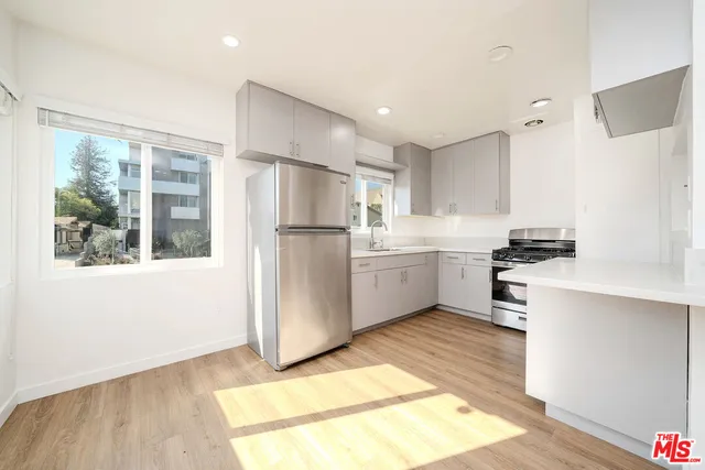 a kitchen with white cabinets and white appliances