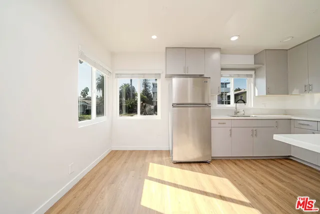 a kitchen with a refrigerator a stove top oven a sink and dishwasher with wooden floor