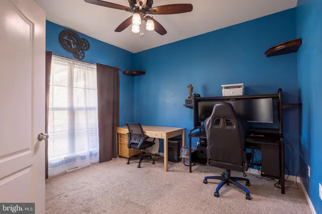 a view of a workspace with furniture and a window