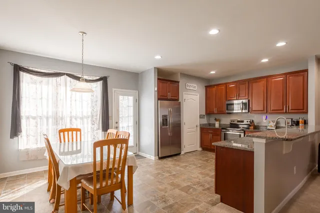 a kitchen with stainless steel appliances granite countertop a stove top oven a refrigerator a sink and dishwasher