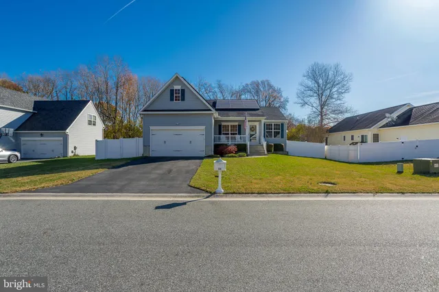 a view of house with a big yard and large trees
