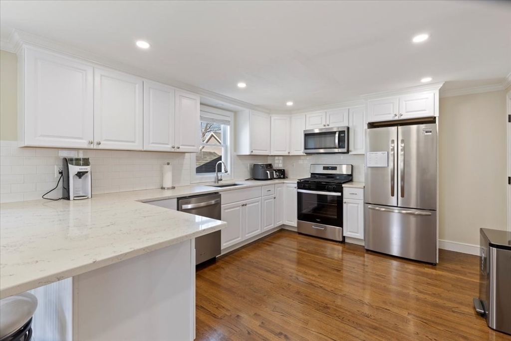 19 Warren Avenue Saugus, MA 01906 - Photo 4 of 33 a kitchen with a refrigerator a stove top oven a sink and cabinets