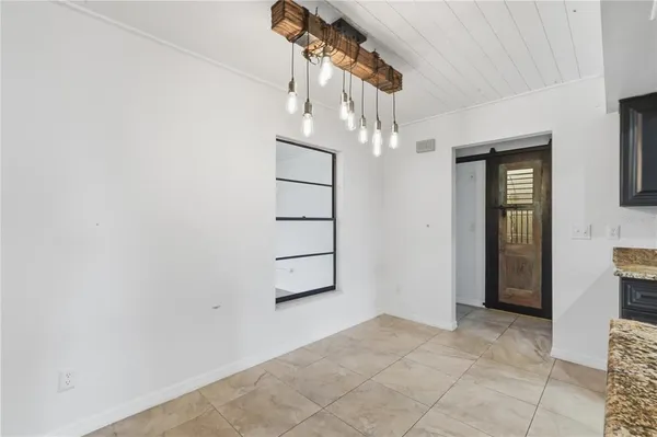 an empty room with chandelier fan