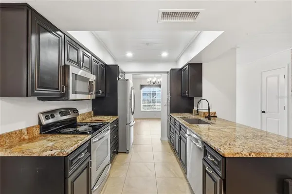 a kitchen with stainless steel appliances granite countertop a sink stove and refrigerator