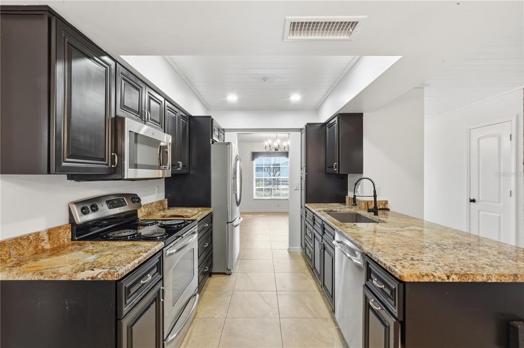 5309 South Farkas Road Plant City, FL 33567 - Photo 18 of 43 a kitchen with stainless steel appliances granite countertop a sink stove and refrigerator