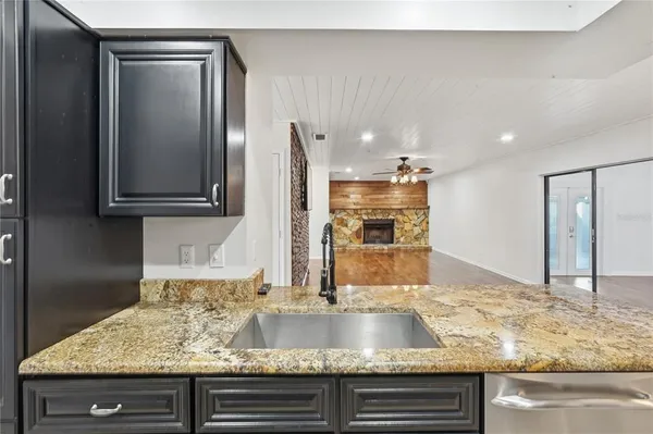 a kitchen with granite countertop a sink and a wooden floor