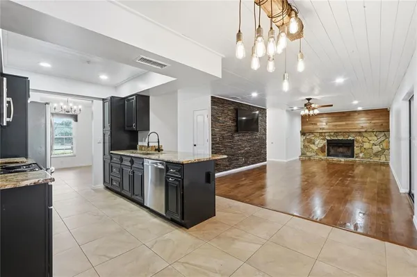 a large kitchen with kitchen island a large counter top and stainless steel appliances
