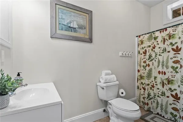 a bathroom with a shower curtain a sink and a toilet
