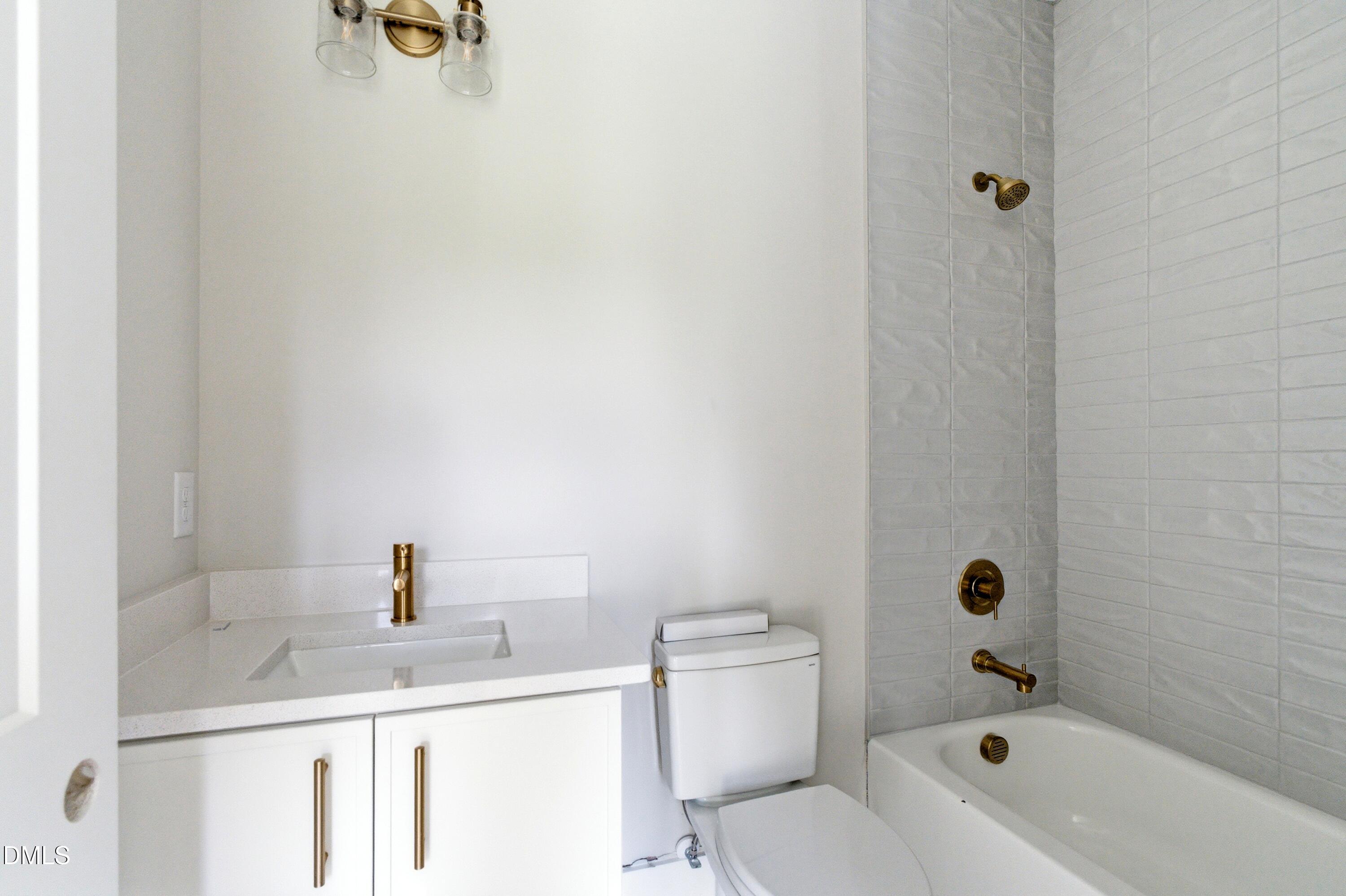 720 Noble Town Way, Unit 106 Raleigh, NC 27603 - Photo 18 of 28 a bathroom with a sink a toilet and shower
