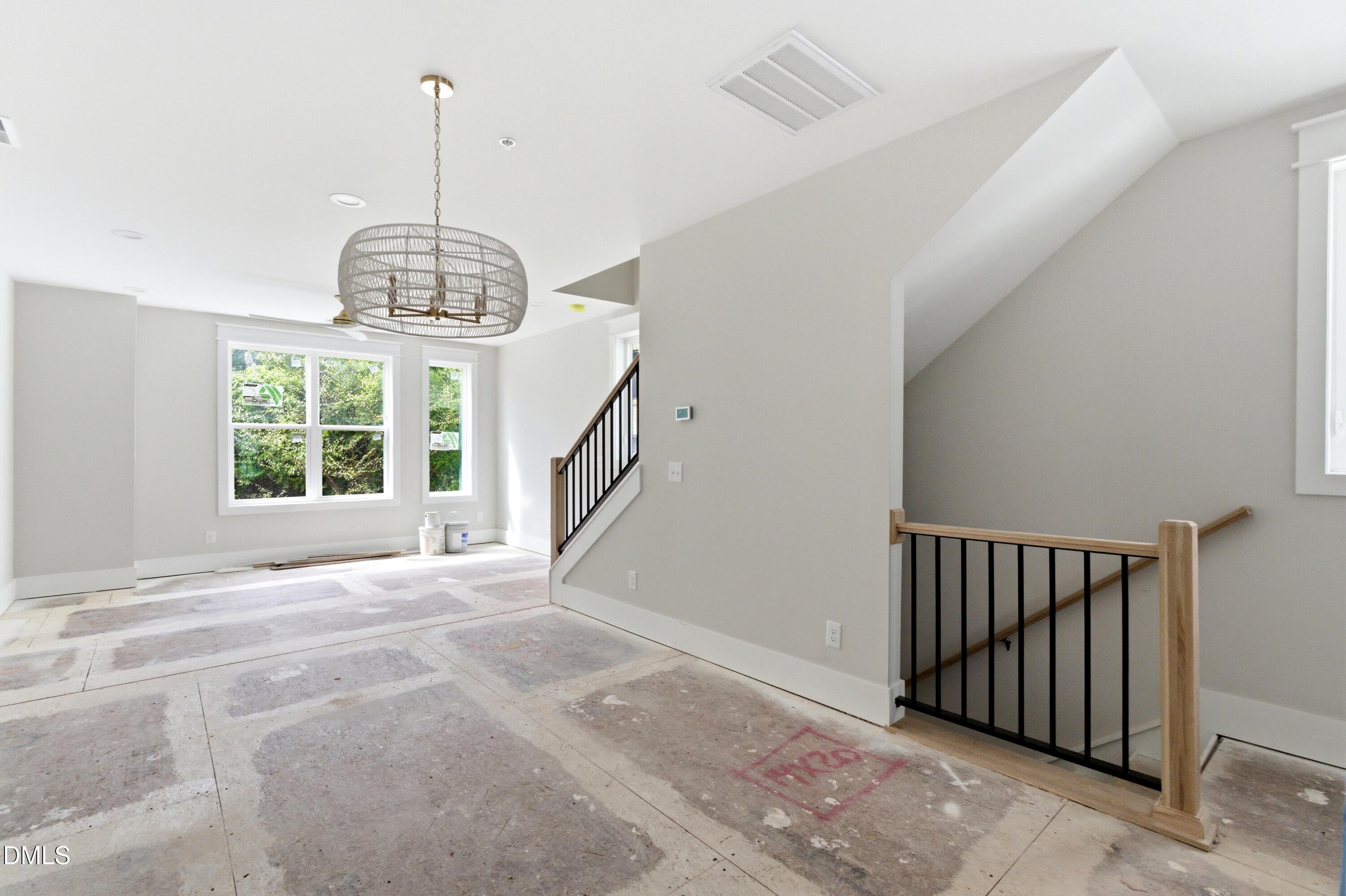 720 Noble Town Way, Unit 106 Raleigh, NC 27603 - Photo 5 of 28 a view of empty room with wooden floor and windows