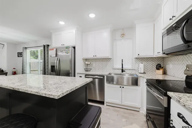 a kitchen with stainless steel appliances granite countertop a sink stove and refrigerator