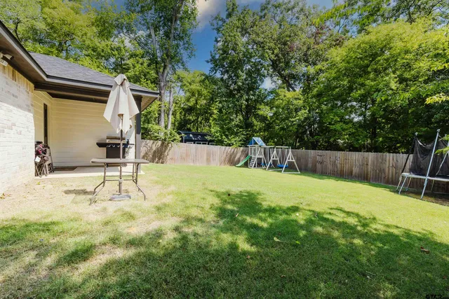 a view of a backyard with a small yard and wooden fence