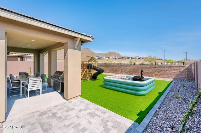 a view of a house with a patio and a yard