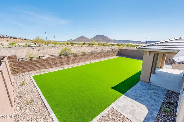 an aerial view of a house with a garden and lake view