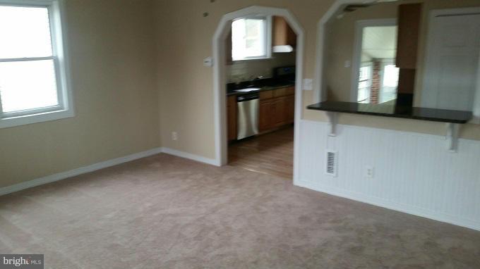 3210 Lynch Road Baltimore, MD 21219 - Photo 5 of 15 an empty room with a fireplace and windows