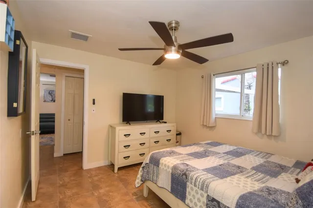 a bedroom with bed tv and a window