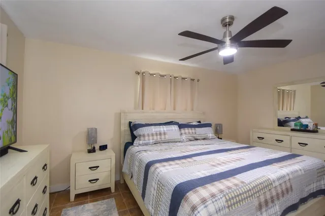 a bedroom with a bed and a tv on the dresser