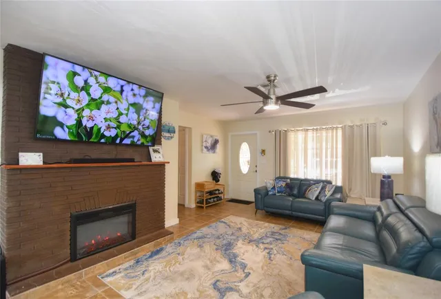 a living room with furniture a fireplace and a flat screen tv