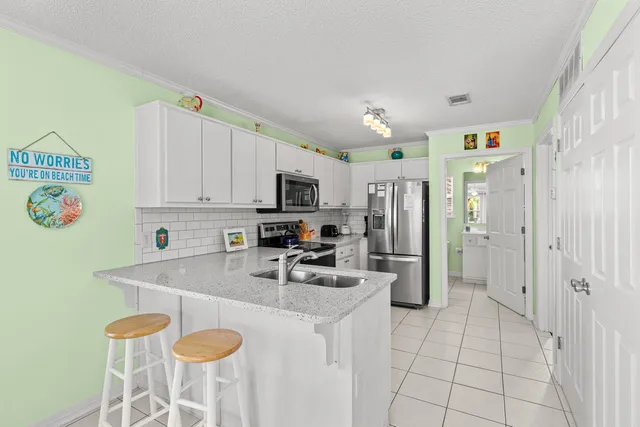 a kitchen with stainless steel appliances granite countertop a sink and a refrigerator