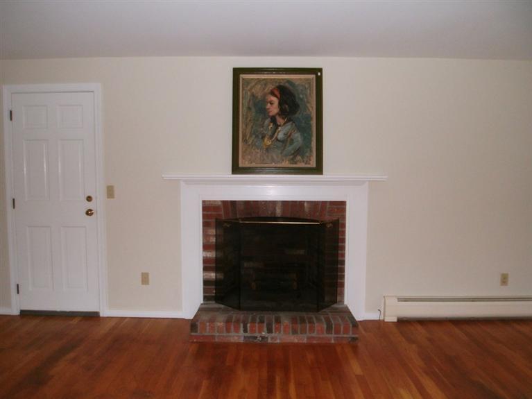 23 Ansel Howland Road Centerville, MA 02632 - Photo 12 of 27 a living room with a fireplace and a wooden floor