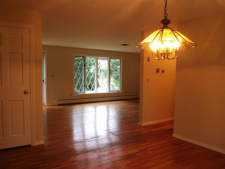23 Ansel Howland Road Centerville, MA 02632 - Photo 21 of 27 an empty room with wooden floor chandelier and windows