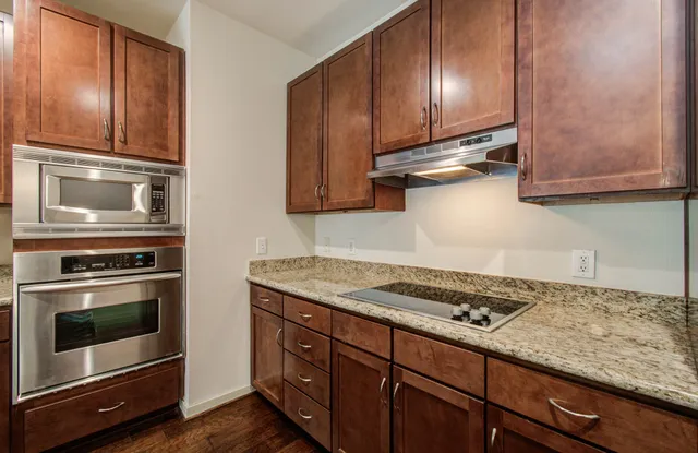a bathroom with a granite countertop sink a toilet and a mirror