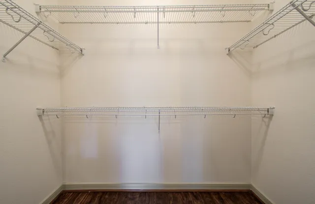 a bathroom with a granite countertop double vanity sink a mirror and a shower