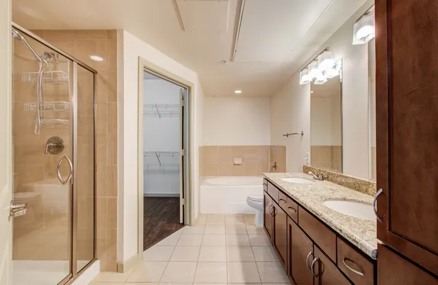 a bathroom with a granite countertop bathtub sink double and mirror