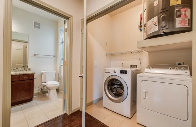 a utility room with dryer washer and a view of bathroom