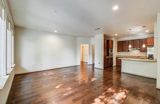 a kitchen with kitchen island granite countertop wooden floors and white stainless steel appliances